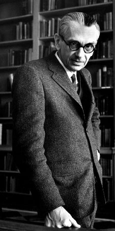 Dressed man with glasses, standing in library, fist firmly planted on the table