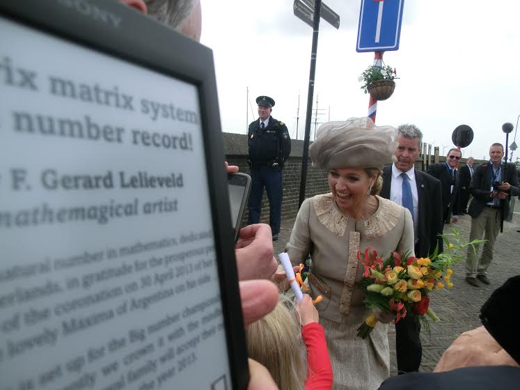 New queen joyously accepts paper scroll from child in crowd